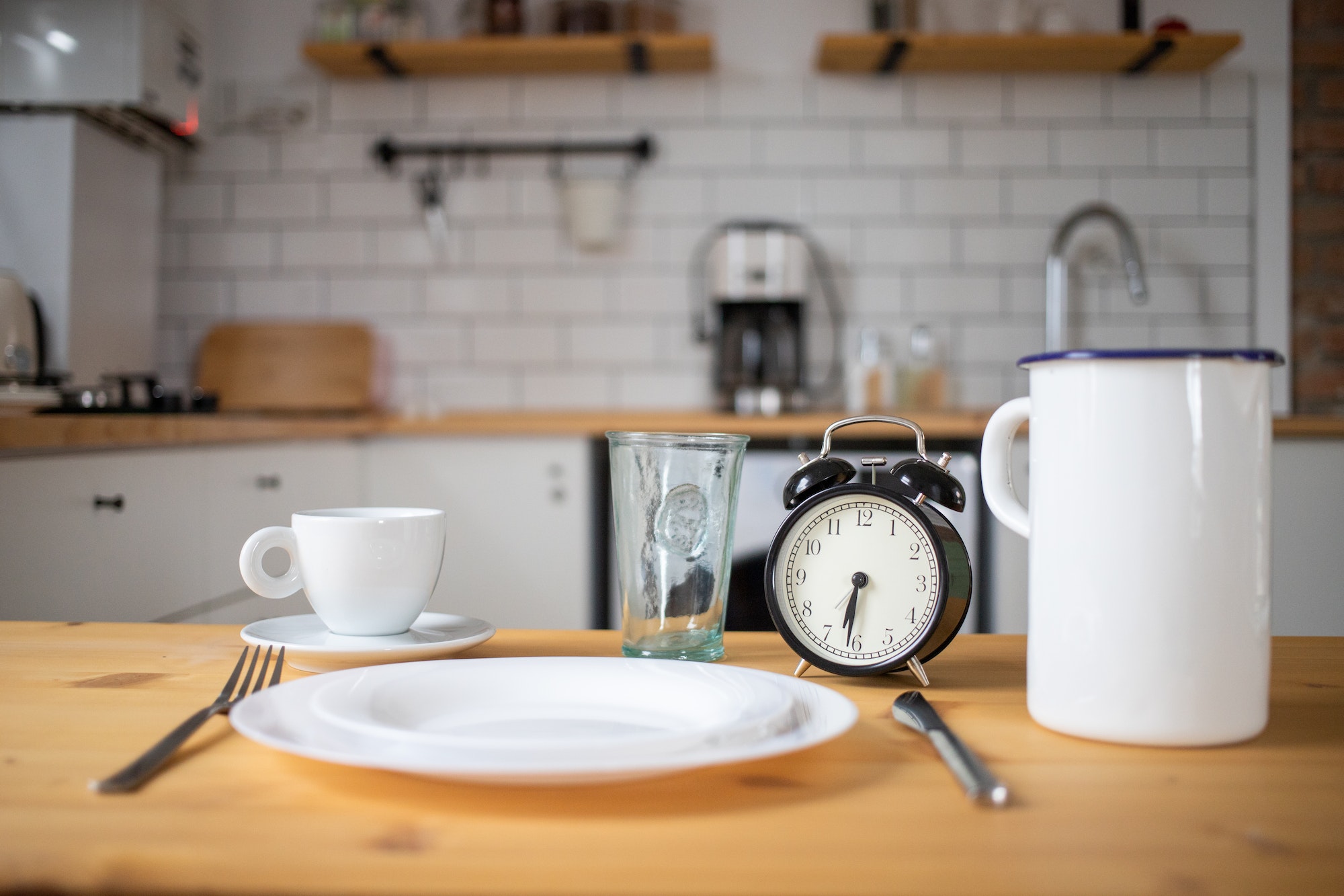 intermittent fasting concept alarm clock on kitchen table